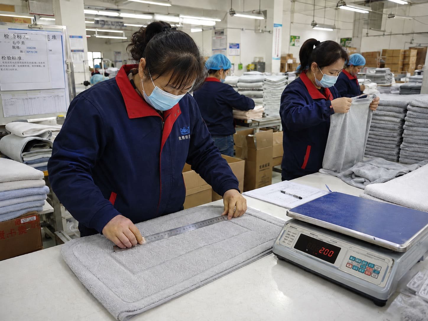 Chinese textile workers inspecting home textile products during production